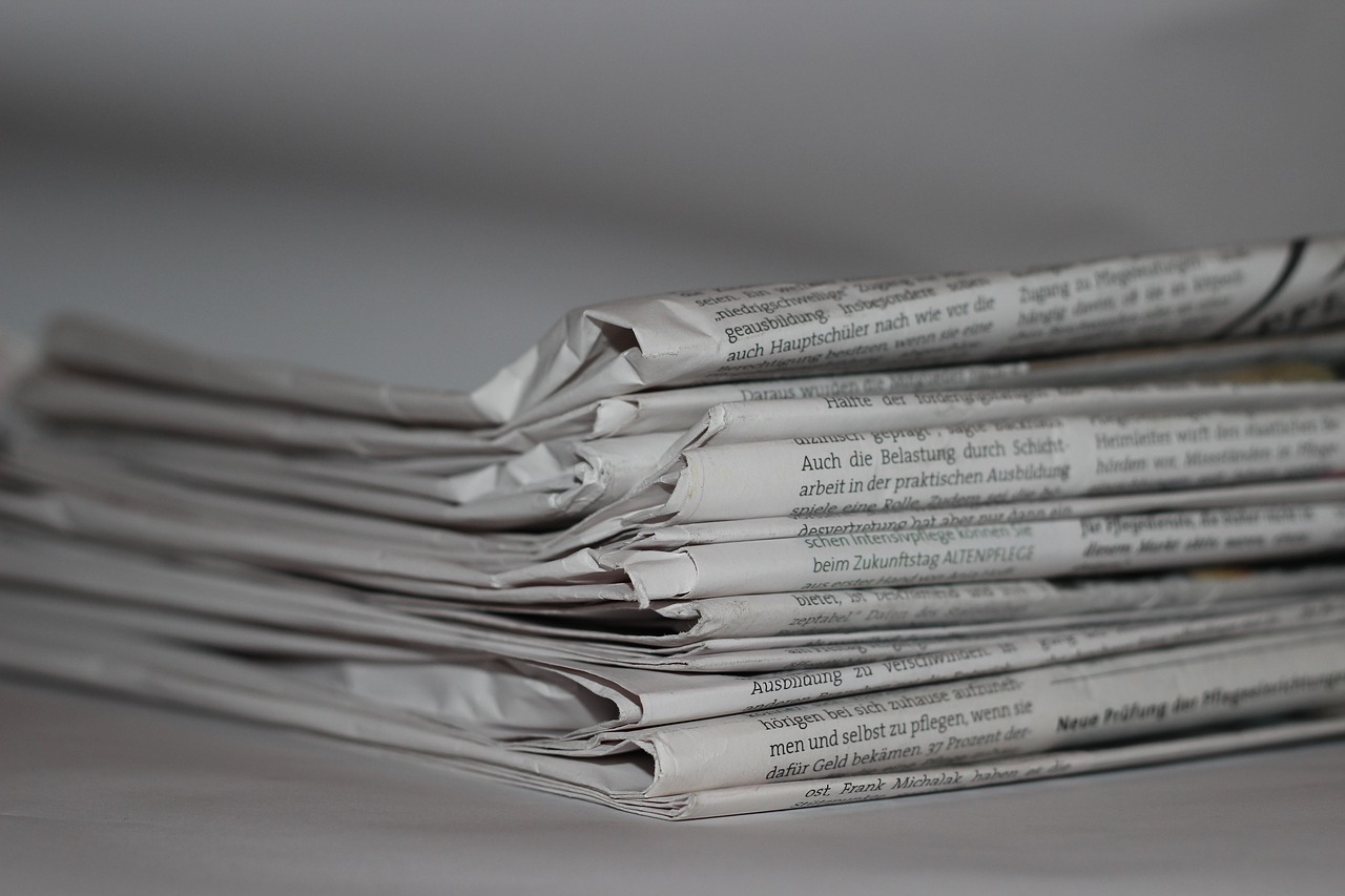 A pile of news papers on a bench