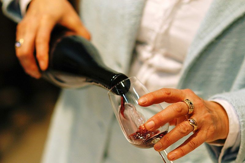 Woman pouring a glass of wine at our Sicily holiday villas