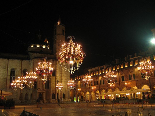 Piazza del Popolo in Le Marche lit up at night. 