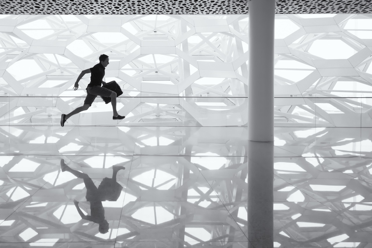 man running through airport with suitcase on his Italian holidays. 