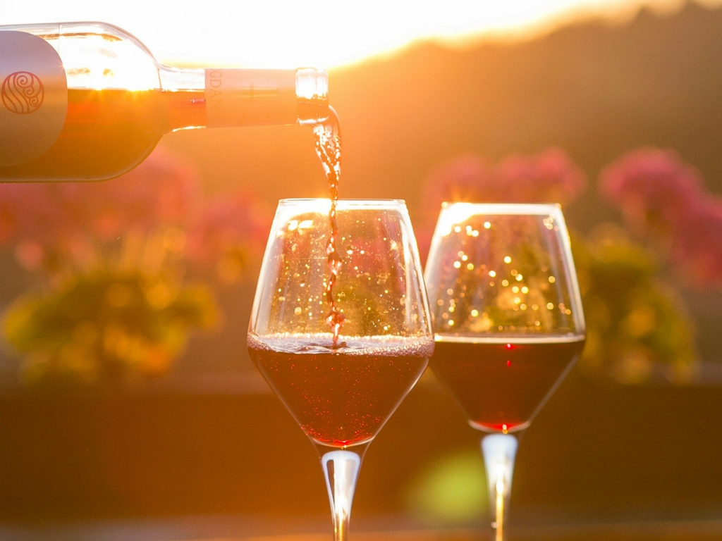 Two glasses of wine being poured from an Italian export bottle of wine 