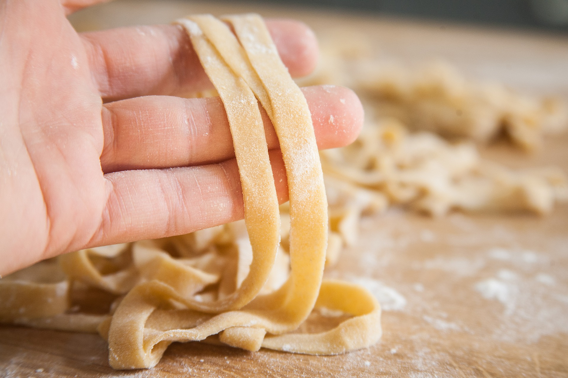 a hand holding fresh pasta. 