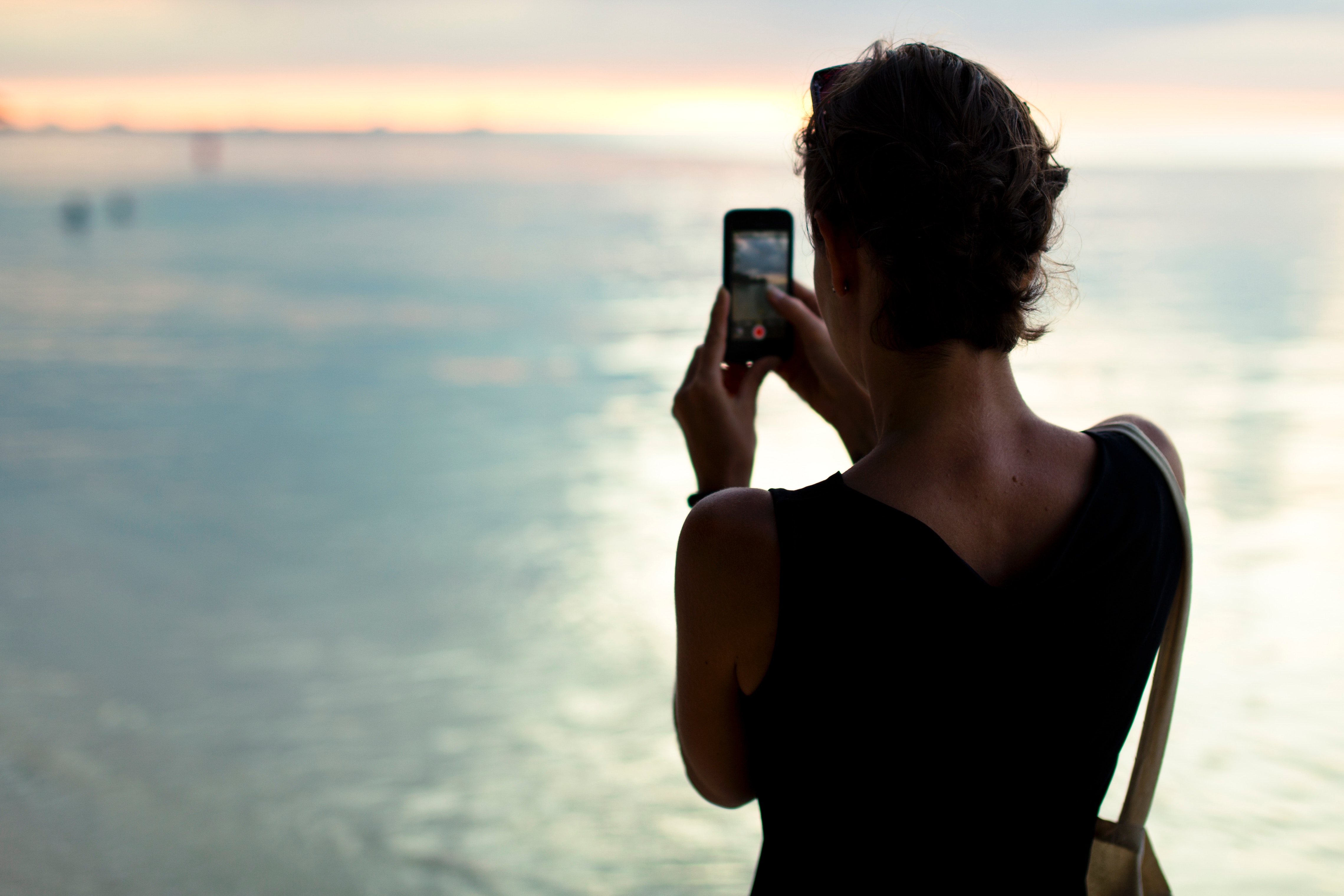 A woman takes an Instagram shot of the sea.