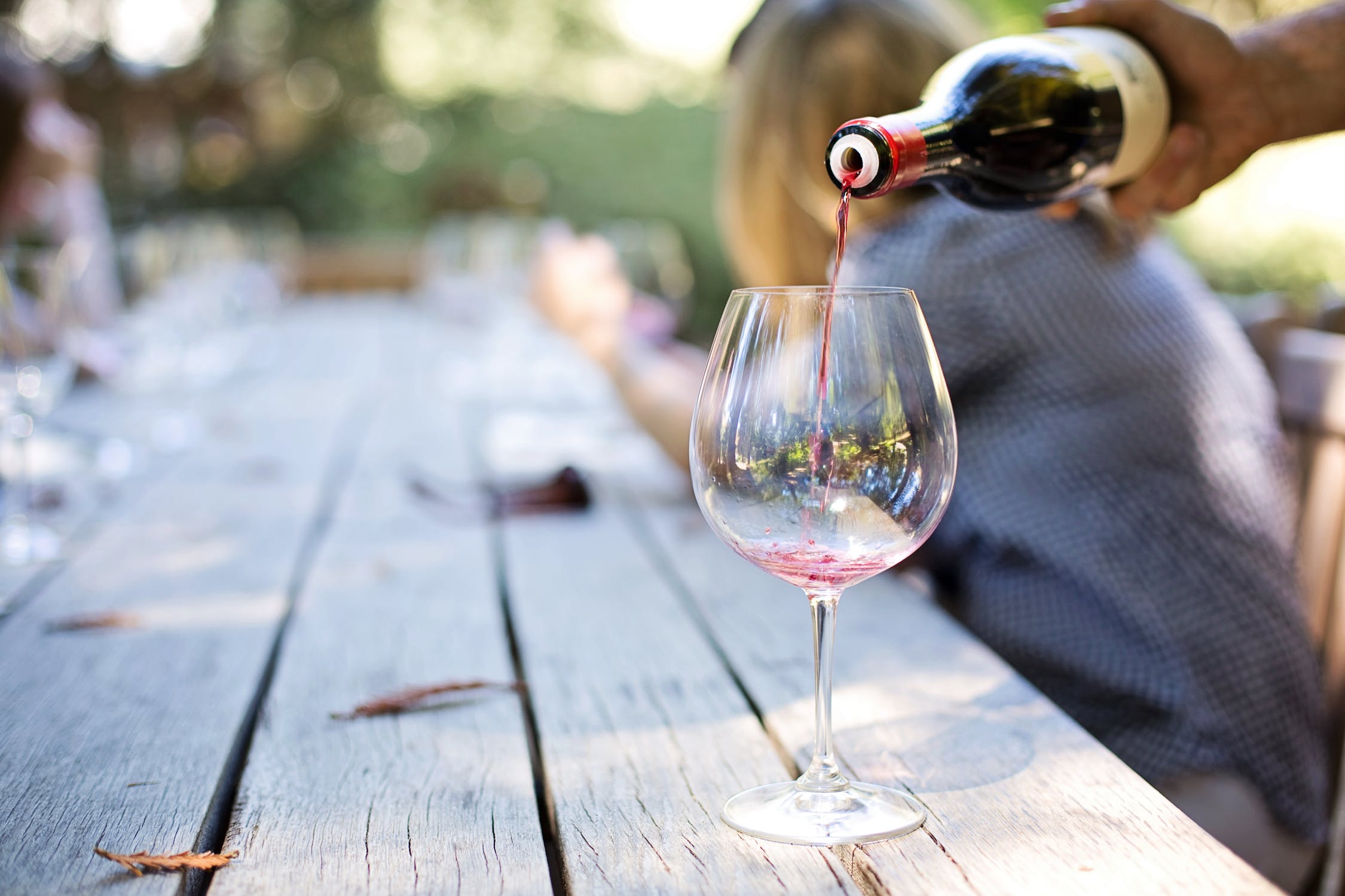 A person pouring some Tuscan red wine into a glass