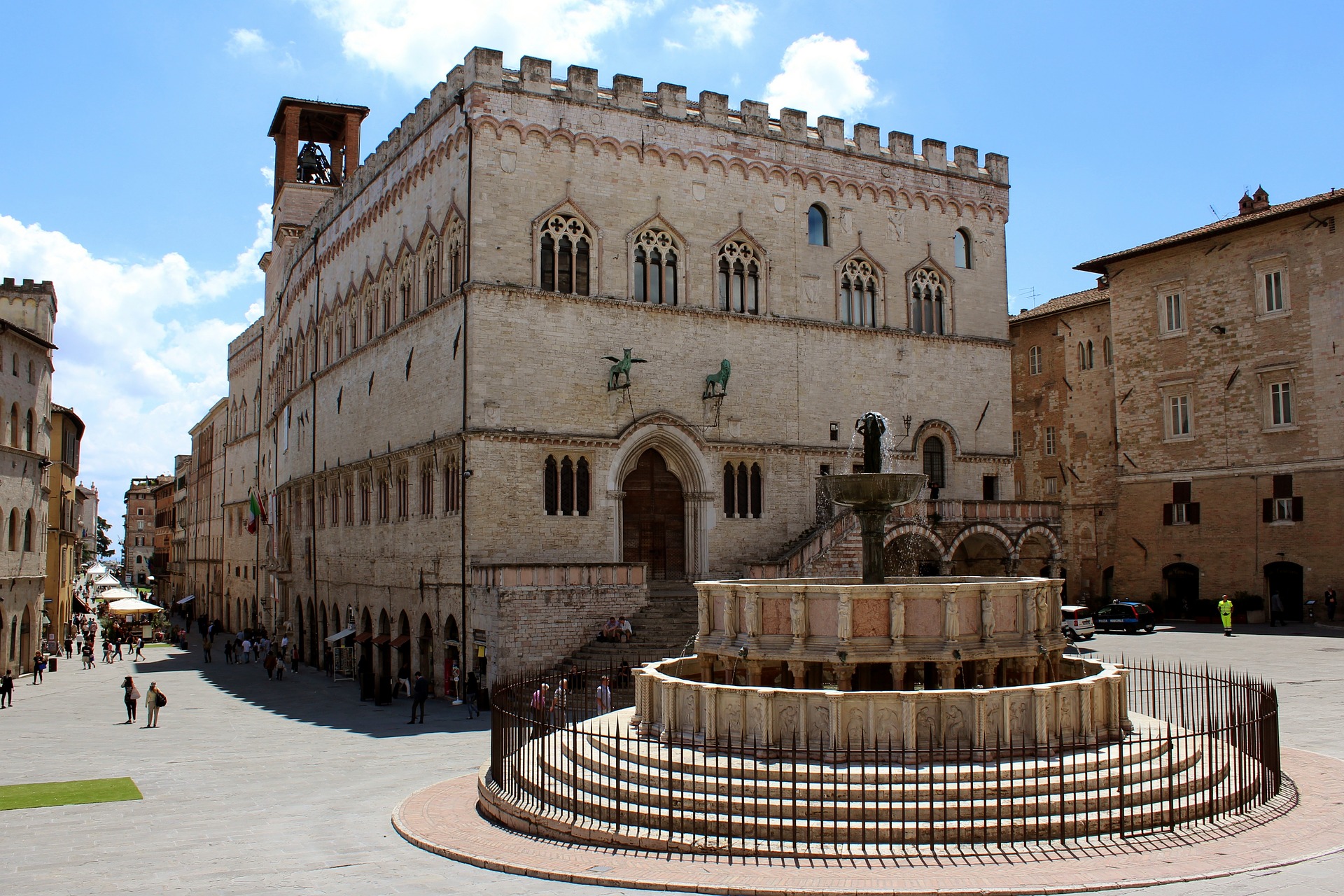 large stone building by a fountain in a town square