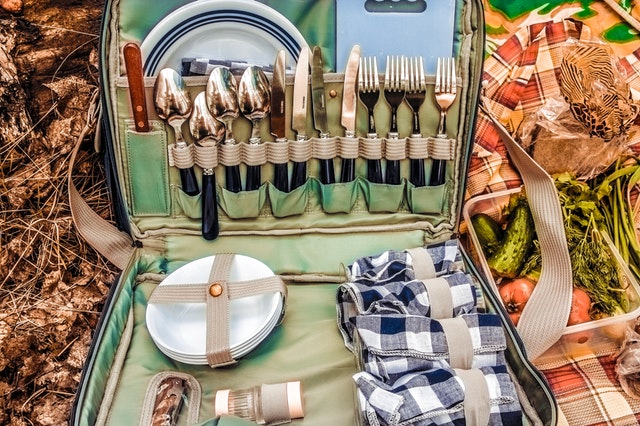 Picnic basket on red and white picnic cloth. 