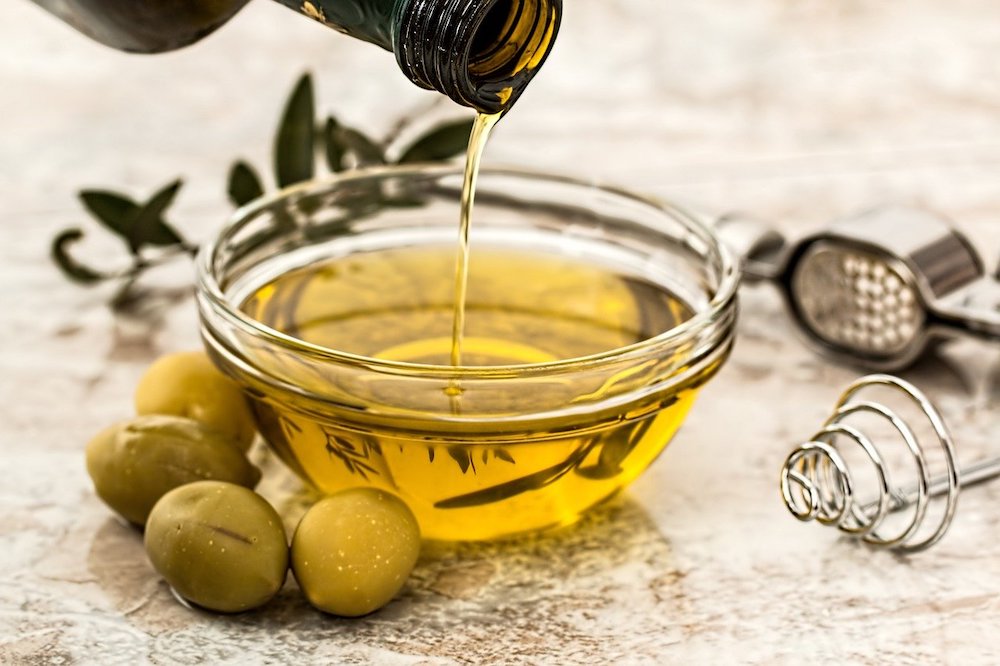 Glass bowl of olive oil.