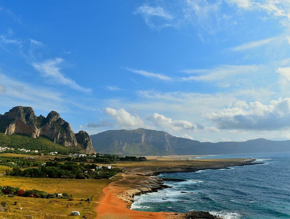 The coast of Sicily on a sunny day, with mountains and grass plains